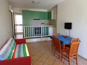 a living room with a table and chairs and a kitchen at Residence la Chimera in Villasimius