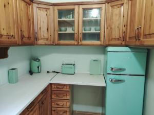 a kitchen with wooden cabinets and a refrigerator at Sunny side apartman in Sopron