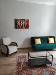 a living room with a green couch and a coffee table at Sunny side apartman in Sopron +2 photos