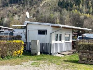 a small white building next to a house at Zillerstadl - 5 Sterne Erlebnisresort Aufenfeld, Aschau in Aschau