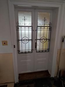 a white door with two windows in a room at Sunny side apartman in Sopron