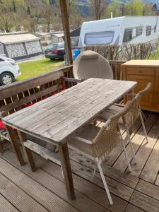 a wooden picnic table and two chairs on a deck at Zillerstadl - 5 Sterne Erlebnisresort Aufenfeld, Aschau in Aschau