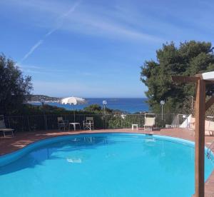 a swimming pool with a view of the ocean at Residence la Chimera in Villasimius
