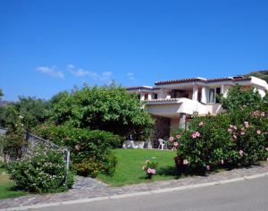 a house with flowers in front of a yard at Residence la Chimera in Villasimius