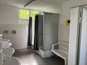 a bathroom with two sinks and a shower and toilets at Nr 6 Camping Pod mit Terrasse und Seeblick in Langenbernsdorf +12 photos