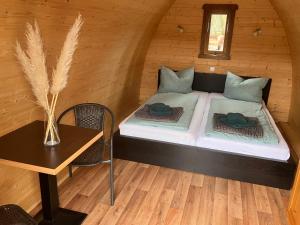 a small room with a bed in a cabin at Nr 6 Camping Pod mit Terrasse und Seeblick in Langenbernsdorf