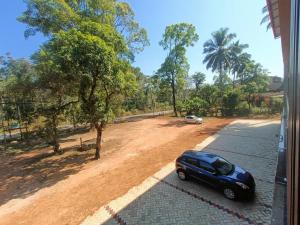 a blue car parked on the side of a road at Gokula Arcade in Subrahmanya