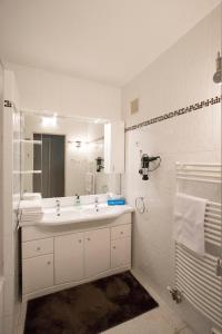 Baño blanco con lavabo y espejo en Les Gémeaux, en Aviñón