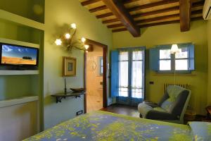 a bedroom with green walls and a bed and a chair at Il Poggio di Teo in Manciano