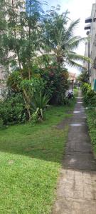 a sidewalk next to a yard with trees and grass at Joy Hostel in Salvador