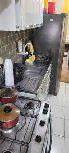 a kitchen with a stove with pots and pans on it at Joy Hostel in Salvador +8 photos