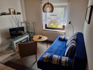 a living room with a blue couch and a television at Ferienwohnung Drechsel in Olbernhau