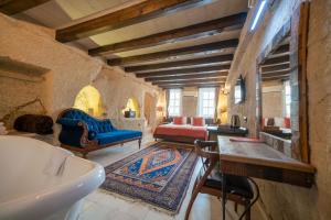 a room with two beds and a table and a sink at Divan Cave House in Göreme
