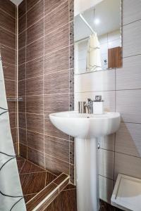a bathroom with a white sink and a mirror at Hestia Apartments in Berovo +88 photos