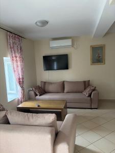 a living room with a couch and a tv at Julia's House in Mikros Gialos