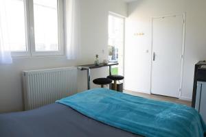 a bedroom with a bed with a blue blanket on it at Garden Spa in Caudebec-lès-Elbeuf
