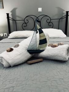 a model sailboat on a bed with a towel at To Balkoni Thanos in Thános