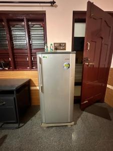 a kitchen with a refrigerator in the middle of a room at Sri Devi Krupa in Hubli