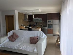 a living room with a white couch in a kitchen at Quarportugal in São Martinho do Porto