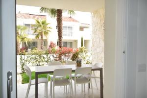 a dining room with a white table and white chairs at VELORA STAYS Florinas in Lido di Jesolo