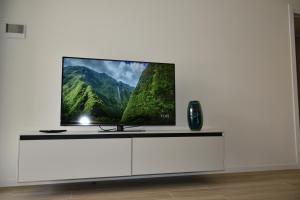 a flat screen tv sitting on top of a white entertainment center at VELORA STAYS Florinas in Lido di Jesolo