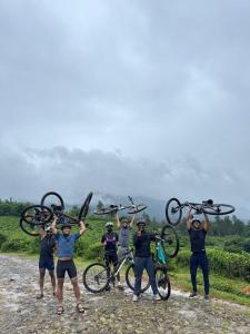 a group of people holding up their bikes at Hibisco Hideout in Meenangadi