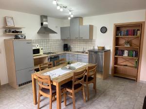 a kitchen with a table and chairs and a refrigerator at Ferienwohnung Ott in Weißenburg in Bayern +6 photos