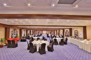 a banquet hall with tables and chairs in a room at Avari Xpress Faisalabad in Faisalabad