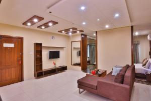 a living room with a couch and a tv at Avari Xpress Faisalabad in Faisalabad