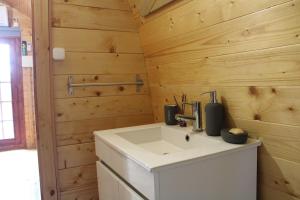 a bathroom with a sink and a wooden wall at Quinta Da Devesa B1 in Vinhais