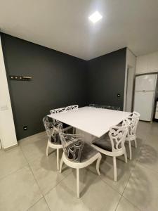 a dining room with a white table and chairs at Apartamento in Socorro +9 photos