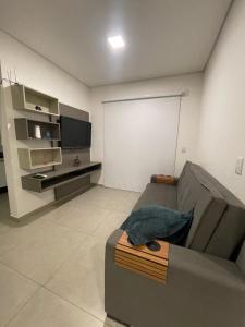 a living room with a gray couch and a tv at Apartamento in Socorro