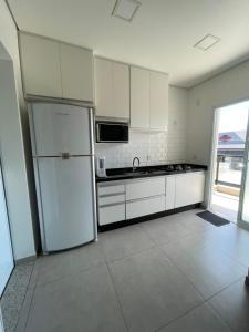 a kitchen with white cabinets and a refrigerator at Apartamento in Socorro