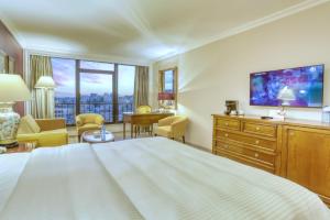 a hotel room with a bed and a television at Regency Palace Amman in Amman