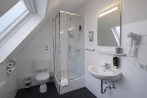a white bathroom with a shower and a sink at Hotel Hansahof Bremen in Bremen +32 photos