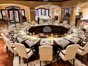 a large dining room with a large table with white chairs at The Imperial, New Delhi in New Delhi