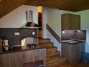a kitchen with a staircase with a sink and a stove at TaTanKa apartments in Batizovce