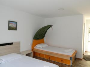 a bedroom with two beds and an orange headboard at Daskalov Bungalows in Chervena Lokva +262 photos