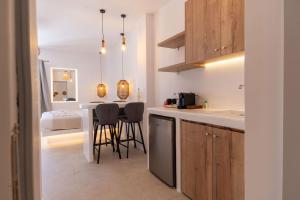 a kitchen with a table and chairs in a room at Aqua Cozy Suites in Perissa +32 photos