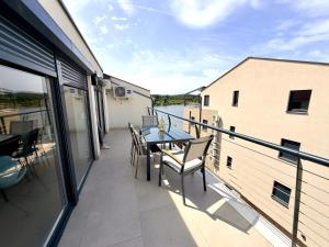 a balcony with a table and chairs on a building at Apartment Lasta Medulin in Medulin
