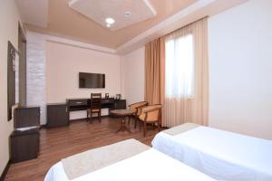 a hotel room with two beds and a desk at Partez Hotel in Yerevan