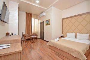 a hotel room with a large bed and a table at Partez Hotel in Yerevan