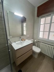 a bathroom with a sink and a toilet and a mirror at Rúa da Igrexa Miño in Miño