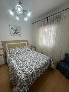 a bedroom with a bed with a black and white comforter at Rúa da Igrexa Miño in Miño