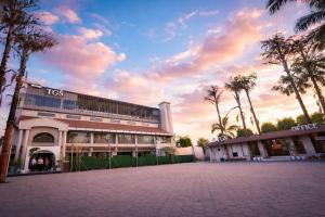 a large building with palm trees in front of it at THE GRAND SUNCITY HOTEL AND RESORT, Bhopal in Bhopal