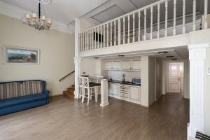 a living room with a loft with a staircase and a kitchen at Metro Hotel Apartments in Odesa