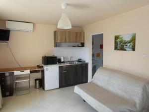 a small kitchen with a bed in a room at Daskalov Bungalows in Chervena Lokva