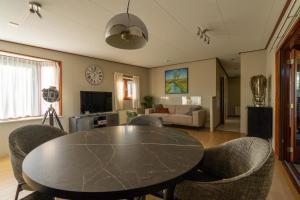 a dining room with a table and chairs and a living room at Grasheide: Modern in Drenthe (4p) in Erm