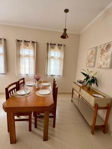 a dining room with a wooden table and chairs at Vila dos Pinheiros 1 in Serra Negra