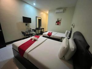a hotel room with two beds and a television at Hollywood Suites Gensan in General Santos